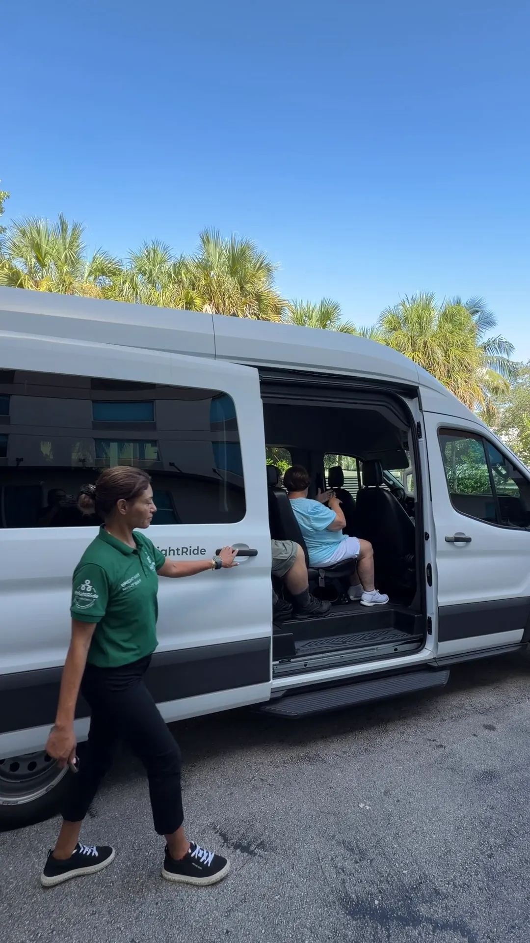 BrightRide driver assisting passengers boarding a shuttle van